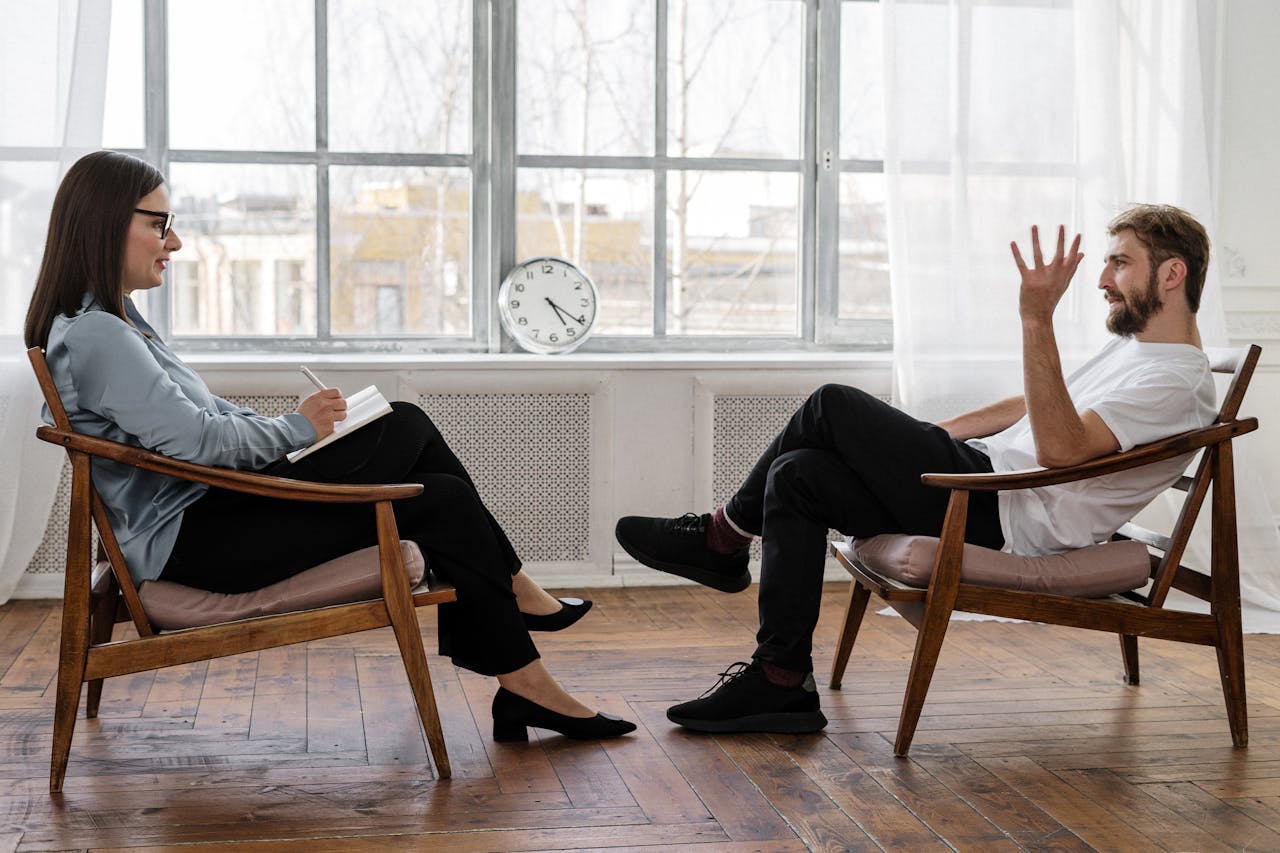 Crafting Captivating Headlines: Your awesome post title goes here A therapist engaging in a counseling session with a male patient to support mental health.
