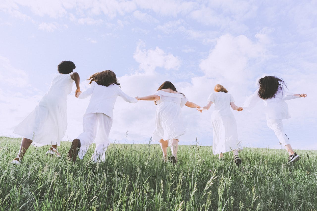 Mastering the First Impression: Your intriguing post title goes here Five women joyfully running in a field under a clear sky, symbolizing freedom and happiness.